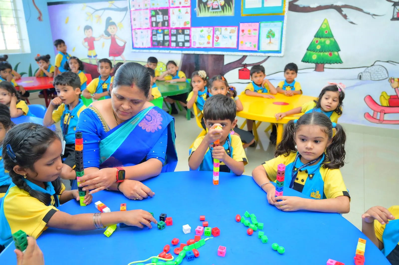 A teacher guiding a hands-on activity at JCS